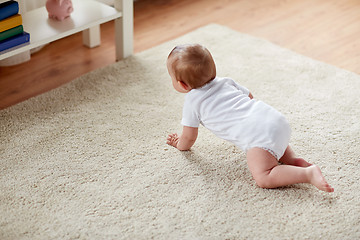 Image showing little baby in diaper crawling on floor at home