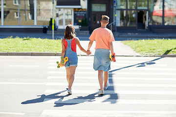 Image showing teenage couple with skateboards on city crosswalk