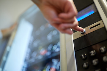 Image showing hand pushing button on vending machine