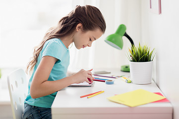 Image showing happy girl drawing at home