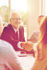 Image showing senior businessman making handshake at office