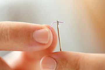 Image showing hands of tailor woman threading needle