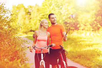 Image showing couple with bicycle and smartphone selfie stick