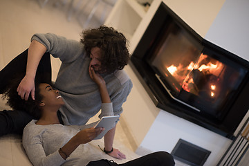 Image showing multiethnic couple used tablet computer on the floor