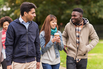 Image showing happy friends walking along autumn park