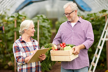 Image showing senior couple with box of vegetables on farm