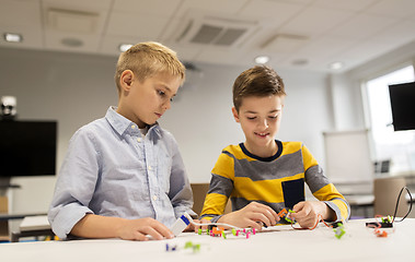 Image showing happy children building robots at robotics school