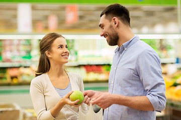 Image showing happy couple buying apples at grocery store