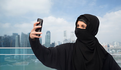 Image showing muslim woman in hijab taking selfie by smartphone