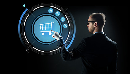 Image showing businessman pointing finger to shopping cart