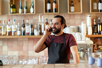 Image showing happy man or waiter at bar calling on smartphone