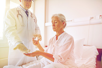 Image showing doctor giving medicine to senior woman at hospital