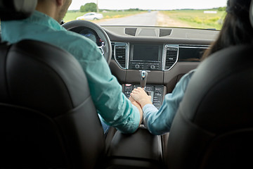 Image showing happy couple driving in car and holding hands