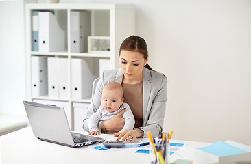 Image showing businesswoman with baby working at office