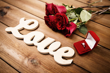 Image showing close up of diamond ring, red roses and word love