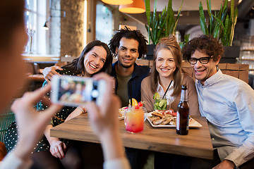 Image showing friends with smartphone photographing at cafe