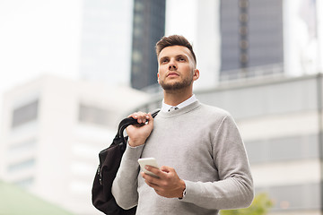 Image showing young man with smartphone and bag in city