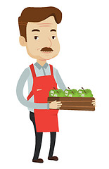 Image showing Supermarket worker with box full of apples.