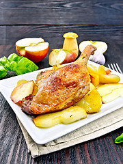 Image showing Duck leg with apple and basil in plate on napkin