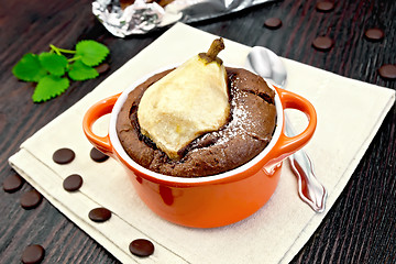 Image showing Cake chocolate with pear in red bowl on napkin