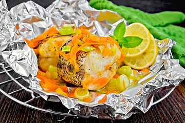 Image showing Pike with carrots and lemon in foil on board