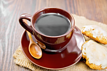 Image showing Coffee in brown cup with cookies on dark board