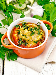 Image showing Fish baked with tomato in red pot on napkin