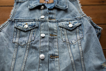 Image showing close up of denim vest or waistcoat on wood