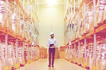 Image showing happy businessman with clipboard at warehouse