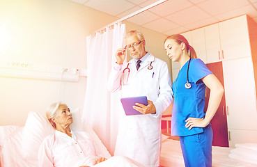 Image showing doctor and nurse visiting senior woman at hospital