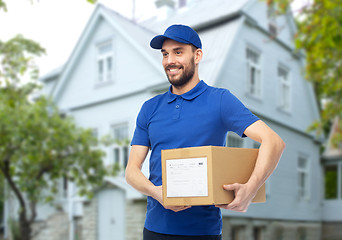 Image showing happy delivery man with parcel box over house