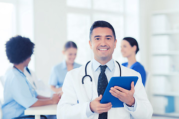 Image showing happy doctor with tablet pc over team at clinic