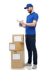 Image showing happy delivery man with parcel boxes and clipboard