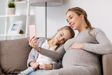 Image showing pregnant woman and girl taking smartphone selfie