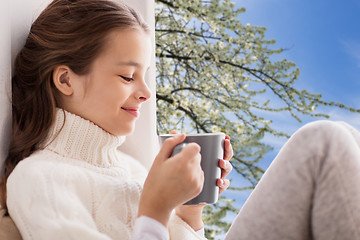 Image showing girl with tea mug sitting at home window