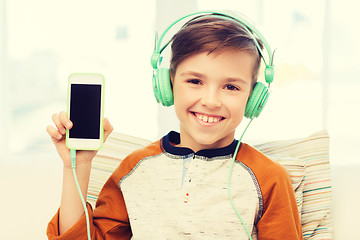 Image showing happy boy with smartphone and headphones at home