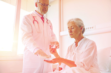 Image showing doctor giving medicine to senior woman at hospital