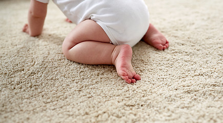 Image showing little baby in diaper crawling on floor at home