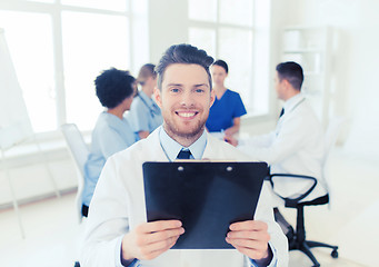 Image showing happy doctor with tablet pc over team at clinic