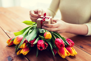 Image showing close up of woman with gift box and tulip flowers