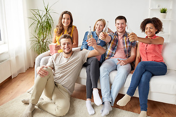 Image showing happy friends with popcorn and beer at home