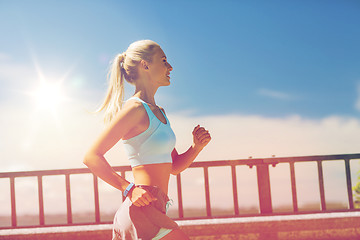 Image showing smiling young woman running outdoors