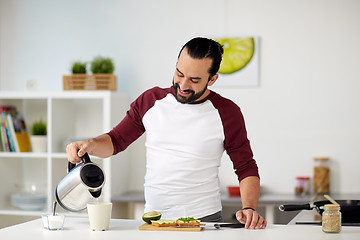 Image showing man with kettle making tea for breakfast at home