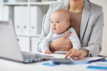 Image showing businesswoman with baby working at office