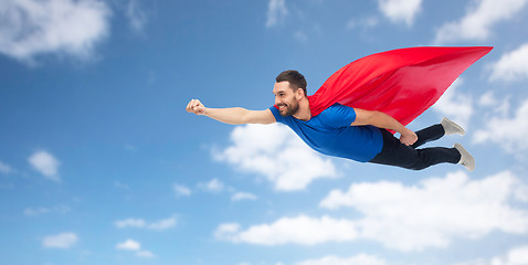 Image showing happy man in red superhero cape flying on air