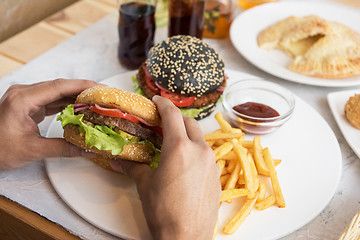 Image showing Man eating burgers