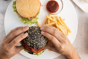Image showing Man eating burgers
