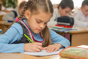 Image showing First grader in class writing in notebook