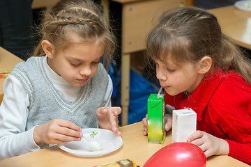 Image showing Two children are drinking juice and eating cake at a party at school