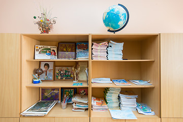 Image showing Cabinet with open shelves in the classroom, a variety of school subjects lie on shelves